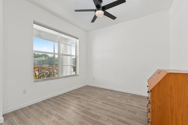 unfurnished room featuring light wood-style floors, baseboards, and a ceiling fan