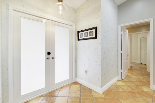 entryway featuring baseboards, french doors, light tile patterned floors, and wallpapered walls