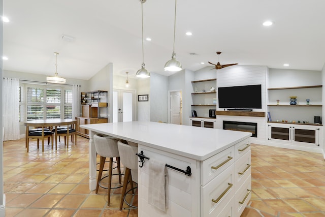 kitchen with lofted ceiling, a center island, light countertops, white cabinetry, and recessed lighting