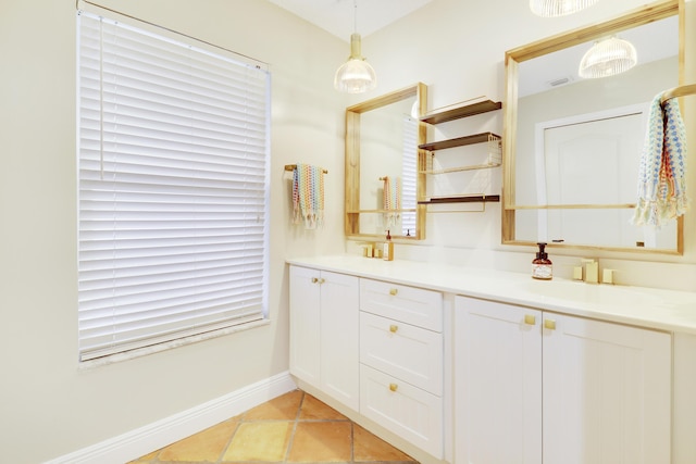 bathroom featuring double vanity, visible vents, a sink, baseboards, and tile patterned floors