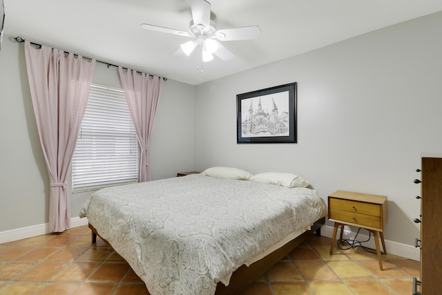 bedroom with a baseboard heating unit, baseboards, and light tile patterned floors