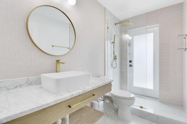 bathroom featuring vanity, tile walls, toilet, and a walk in shower