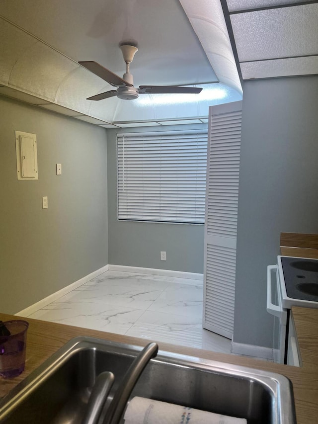 kitchen with marble finish floor, ceiling fan, white electric stove, and baseboards