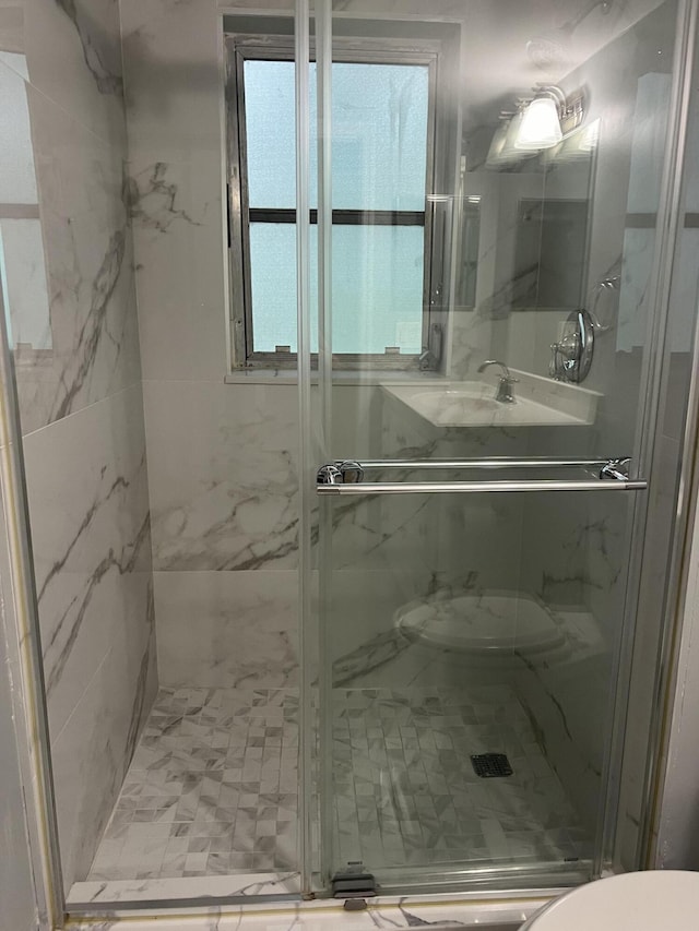 full bathroom featuring toilet and a marble finish shower