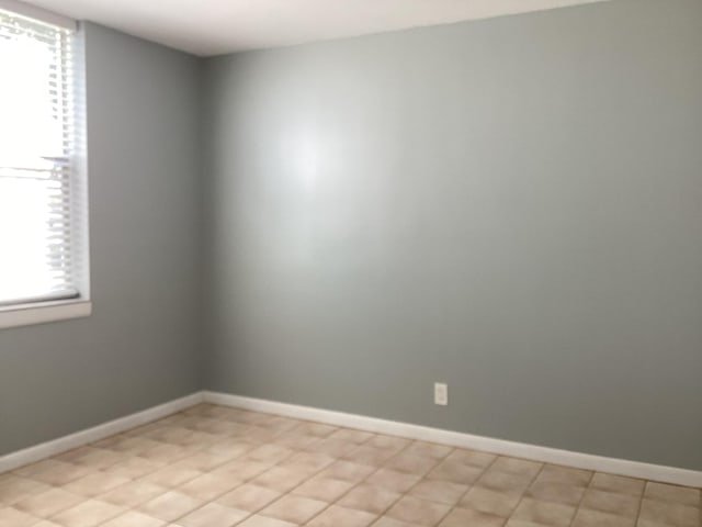 unfurnished room with baseboards