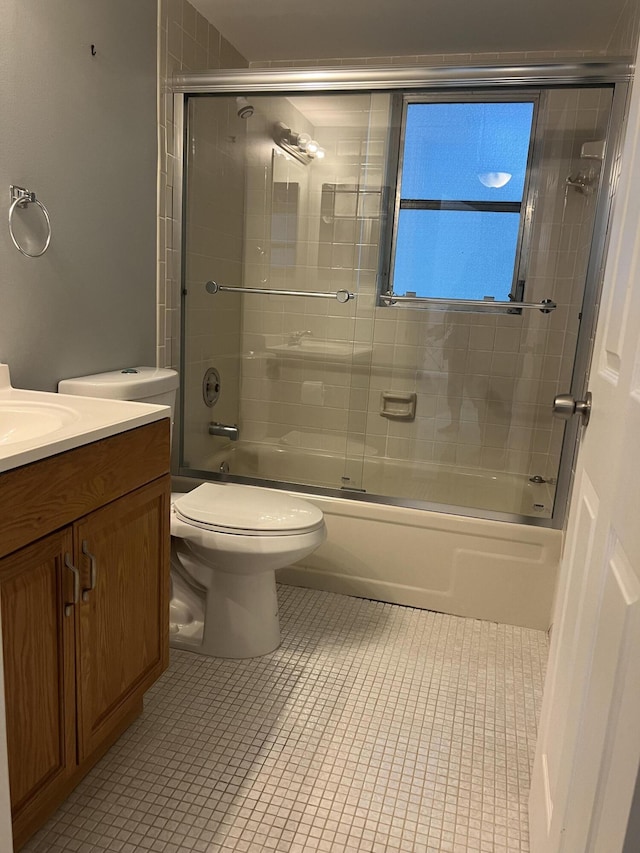 full bath featuring toilet, tile patterned flooring, bath / shower combo with glass door, and vanity