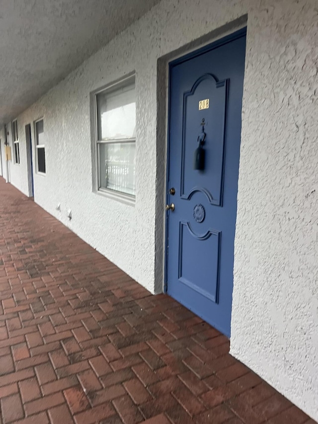 property entrance with stucco siding