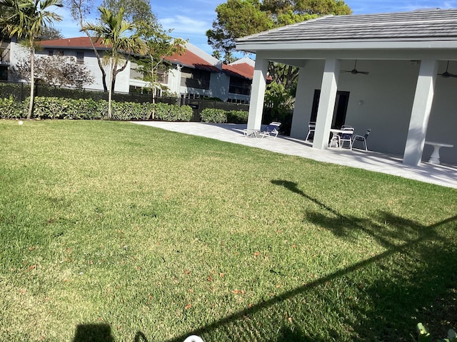 view of yard with ceiling fan, a patio, and fence