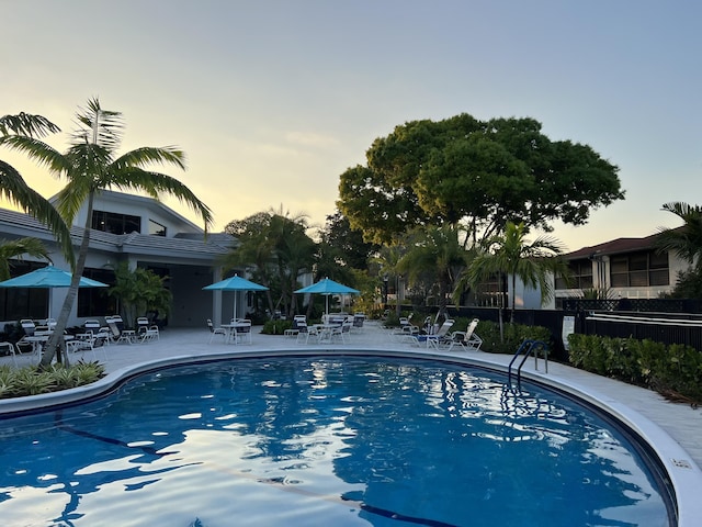 view of swimming pool featuring fence and a patio