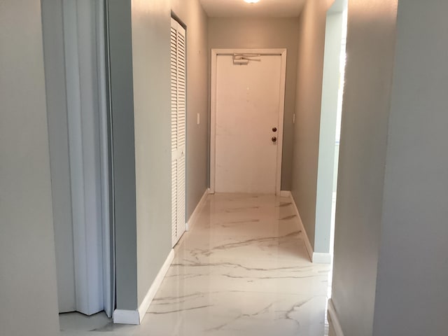 hallway with marble finish floor and baseboards