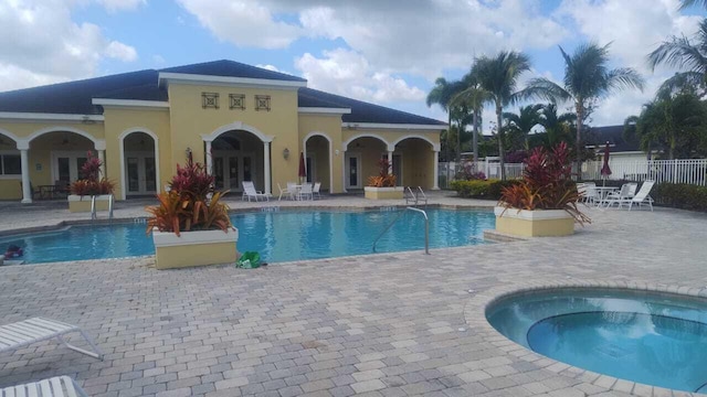 6259 NW Regent St, Port Saint Lucie, FL 34983 - pool with fence, french doors, a community hot tub, and a patio area