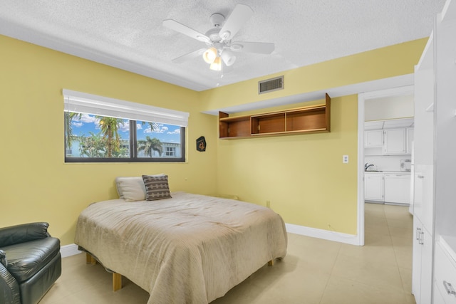 bedroom with visible vents, light tile patterned flooring, ceiling fan, a textured ceiling, and baseboards