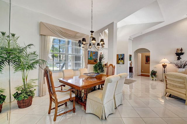 dining room with high vaulted ceiling, arched walkways, light tile patterned flooring, and a notable chandelier