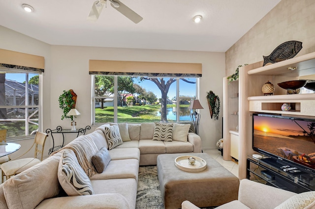 living room featuring light tile patterned floors, plenty of natural light, and ceiling fan