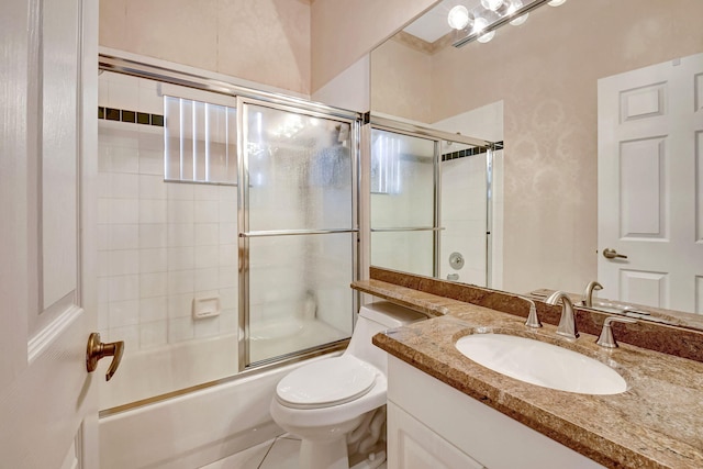 bathroom featuring vanity, toilet, and bath / shower combo with glass door