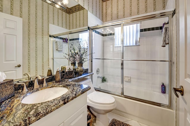 full bathroom with bath / shower combo with glass door, toilet, vanity, tile patterned flooring, and wallpapered walls