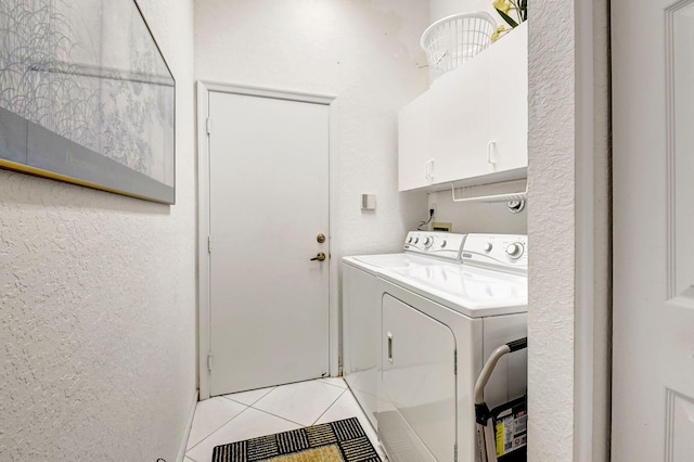 washroom featuring cabinet space, separate washer and dryer, and light tile patterned flooring