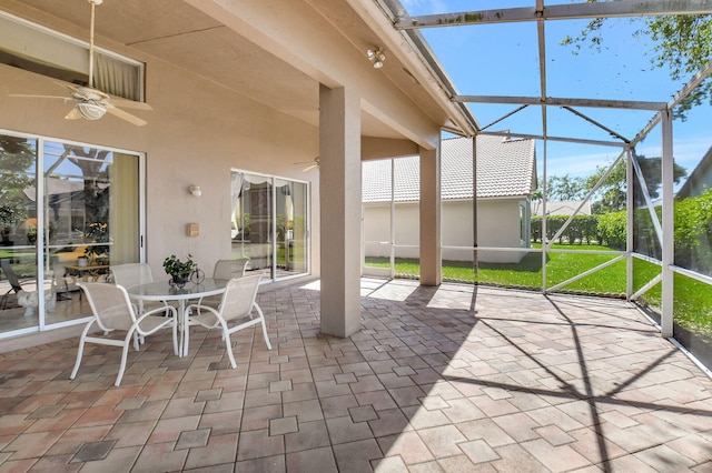 unfurnished sunroom with ceiling fan