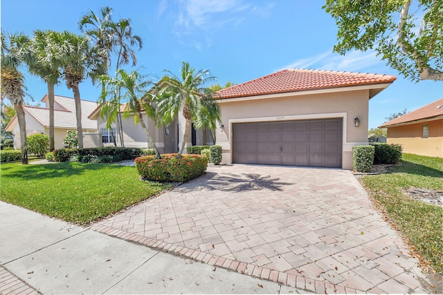 view of front facade featuring decorative driveway, stucco siding, a garage, a tiled roof, and a front lawn