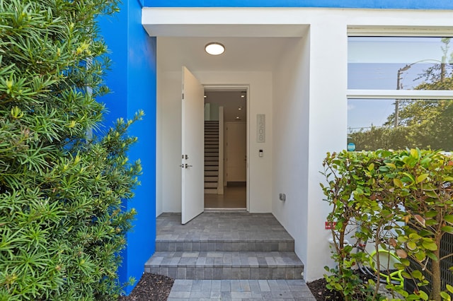 doorway to property featuring stucco siding