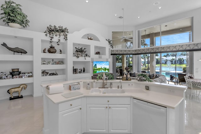 kitchen featuring a sink, open floor plan, white cabinetry, white dishwasher, and light countertops