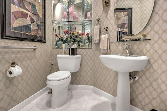 bathroom featuring wallpapered walls, tile patterned floors, toilet, and baseboards