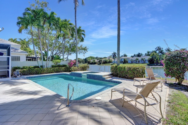 view of swimming pool featuring a patio, a pool with connected hot tub, and fence