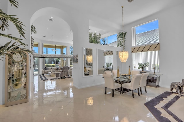 dining room featuring tile patterned floors, visible vents, arched walkways, and a notable chandelier