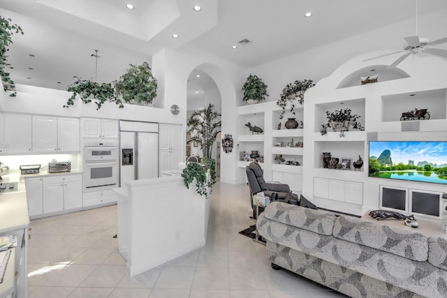 kitchen featuring built in shelves, white cabinetry, double oven, light tile patterned flooring, and paneled built in refrigerator