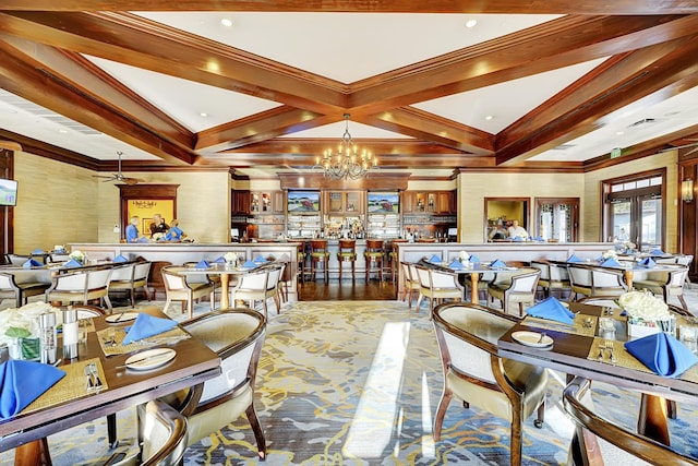 dining space with crown molding, a chandelier, beam ceiling, and french doors