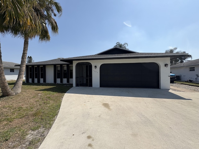 ranch-style house with a front lawn, concrete driveway, an attached garage, and stucco siding