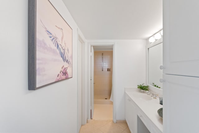 full bath featuring double vanity, a sink, a shower stall, and tile patterned floors