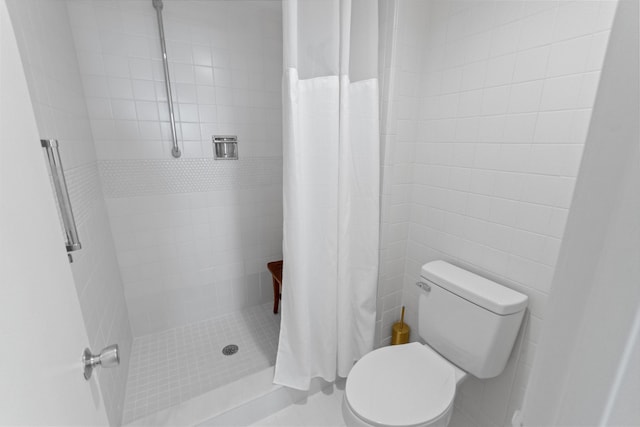 bathroom featuring a stall shower and toilet