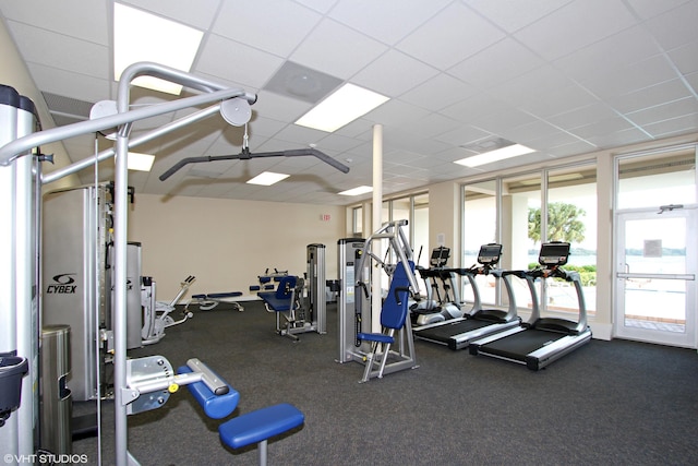 exercise room featuring a paneled ceiling and expansive windows