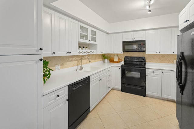 kitchen with black appliances, tasteful backsplash, white cabinets, and a sink