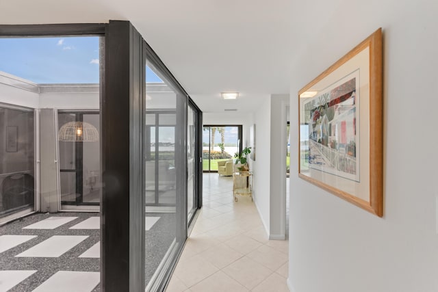 hallway with light tile patterned flooring and baseboards