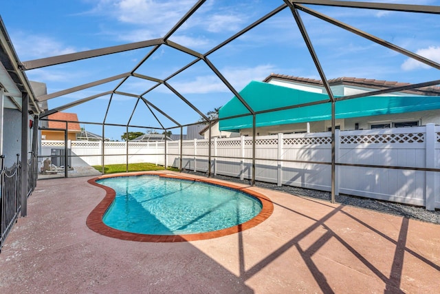 view of pool featuring glass enclosure, a fenced backyard, a fenced in pool, and a patio