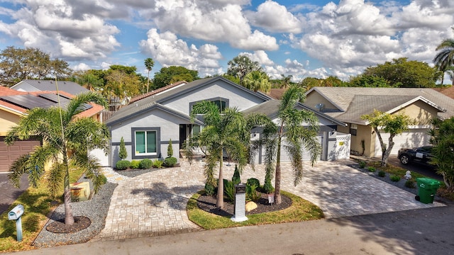 view of front facade featuring an attached garage, decorative driveway, and stucco siding