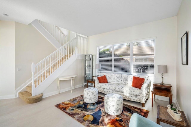 living room with stairs, baseboards, and wood finished floors