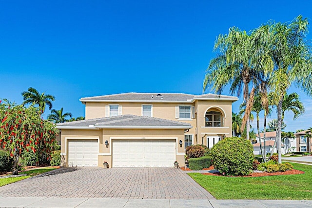 view of front of home with decorative driveway, a tile roof, and stucco siding