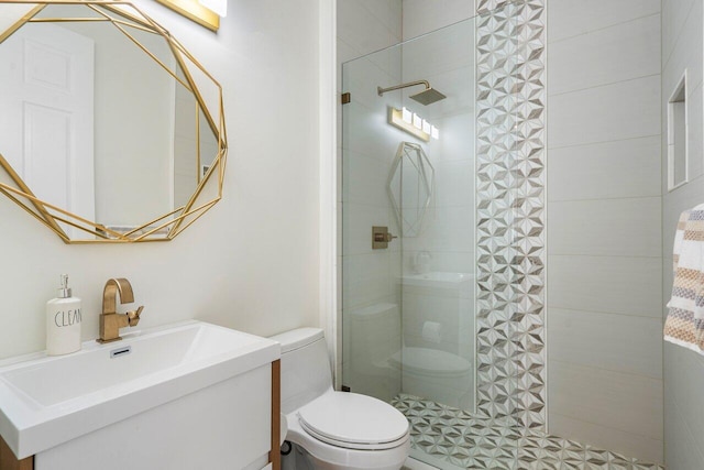 bathroom featuring tiled shower, toilet, and vanity