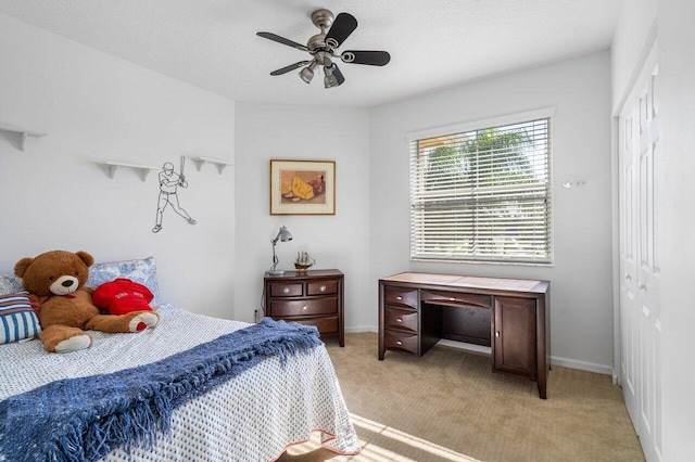 bedroom with baseboards, light colored carpet, a ceiling fan, and a textured ceiling