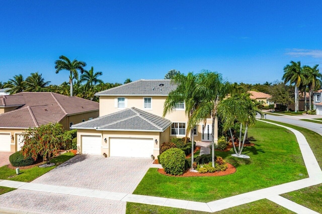 view of front of home with stucco siding, a tile roof, decorative driveway, an attached garage, and a front yard