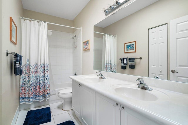 bathroom with tile patterned flooring, double vanity, toilet, and a sink