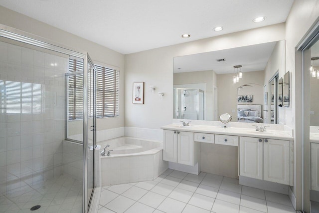 ensuite bathroom with connected bathroom, tile patterned floors, a stall shower, a bath, and a sink