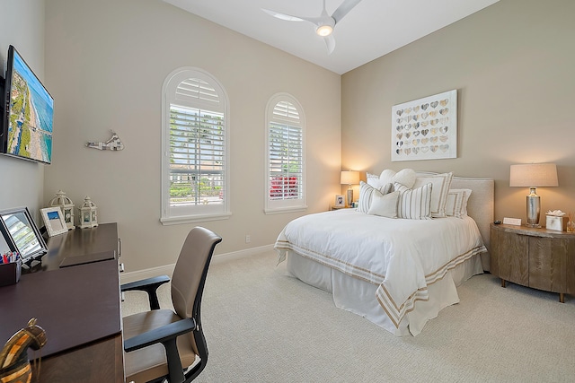 bedroom featuring a ceiling fan, light carpet, and baseboards