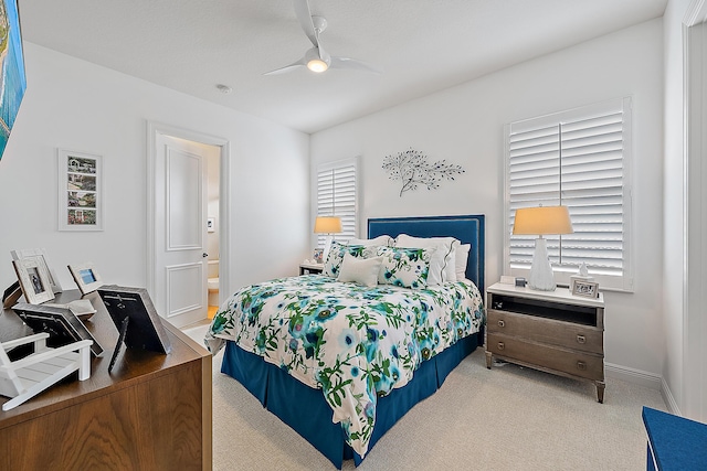 carpeted bedroom with ceiling fan, connected bathroom, and baseboards