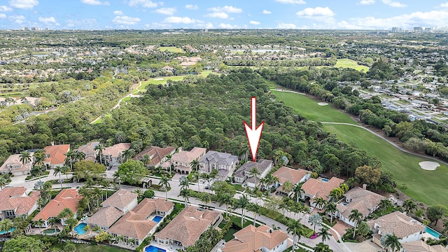 drone / aerial view featuring view of golf course and a residential view