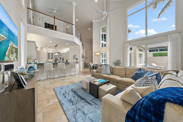 living room with recessed lighting, a high ceiling, a ceiling fan, ornamental molding, and stone tile flooring