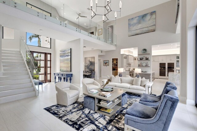 tiled living area with a high ceiling, stairs, and a chandelier